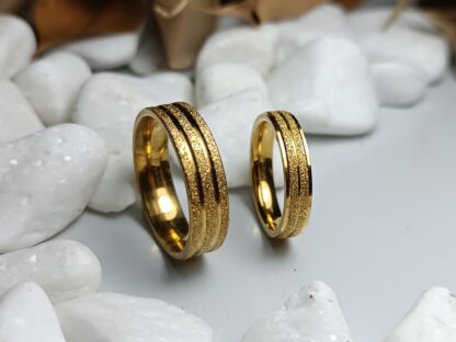 A pair of gold-colored polished steel wedding rings (CODE: 0110)