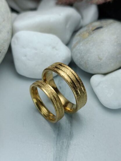 A pair of gold-colored polished steel wedding rings (CODE: 0110)