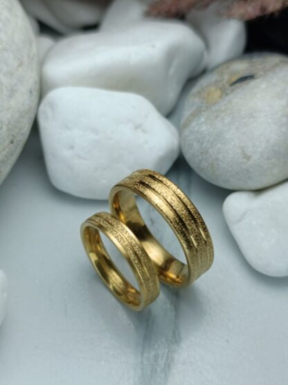 A pair of gold-colored polished steel wedding rings (CODE: 0110)