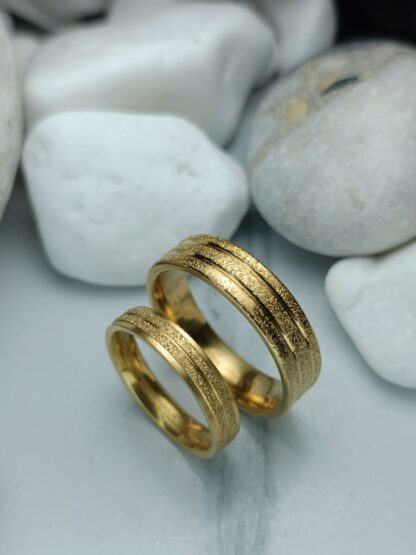 A pair of gold-colored polished steel wedding rings (CODE: 0110)